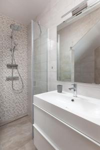 a white bathroom with a sink and a shower at Apartments Galic in Podgora