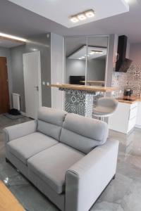 a living room with a white couch and a table at Apartament Panorama in Nowy Targ