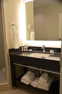 a bathroom with a sink, toilet, and mirror at Tower Hotel at Fallsview in Niagara Falls