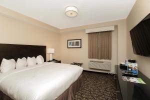 a hotel room with a large white bed and a window at Tower Hotel at Fallsview in Niagara Falls