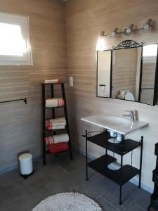 ein Bad mit einem Waschbecken und einem Spiegel in der Unterkunft Le Jardin in Lison