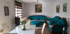 a living room with blue chairs and a table at Apartment Beha in Bihać