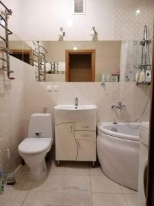 a bathroom with a toilet and a sink and a tub at Вишенка in Vinnytsya +5 photos
