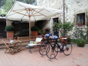 two bikes parked under an umbrella on a patio at Podere San Quirico in Castelnuovo Berardenga
