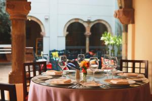 a table with wine glasses and plates on it at San Agustin El Dorado in Cusco