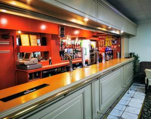 a bar with a wooden counter and red walls at Castle Hotel in Merthyr Tydfil