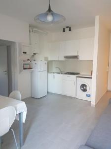 a white kitchen with a washer and dryer in it at RESIDENCE Green Beverly con piscina in Lido Adriano