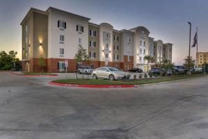 ブライアンにあるCandlewood Suites College Station by IHGの建物の前の駐車場に駐車された車