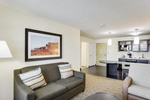 a living room with a couch and a kitchen at Candlewood Suites College Station by IHG in Bryan