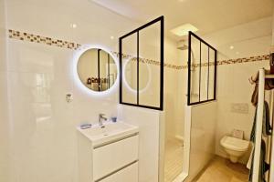 a white bathroom with a sink and a toilet at La Longère in Bonneville-sur-Touques