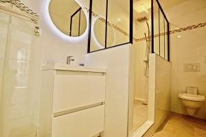 a white bathroom with a shower and a toilet at La Longère in Bonneville-sur-Touques