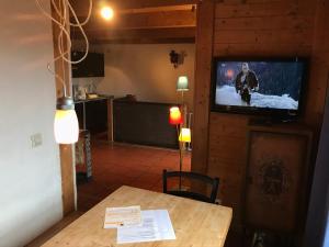 uma sala de estar com uma mesa e uma televisão na parede em Ferienwohungen Gibbesbachhof em Triberg