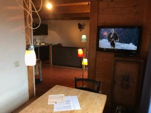 ein Wohnzimmer mit einem Tisch und einem TV an der Wand in der Unterkunft Ferienwohungen Gibbesbachhof in Triberg