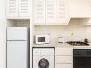 a kitchen with a washing machine and a microwave at Duplex Son Parc Vistas Costa Norte in Es Mercadal