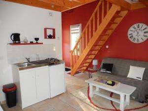eine Küche und ein Wohnzimmer mit einer Uhr an der Wand in der Unterkunft Chambre D'Hôtes Les Jards in Bressuire