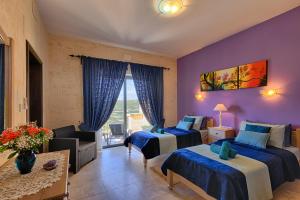 a bedroom with two beds and a living room at Ghajn Damma in Xagħra