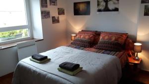 a bedroom with a bed with two pillows on it at Chez Cathy in Loscouët-sur-Meu