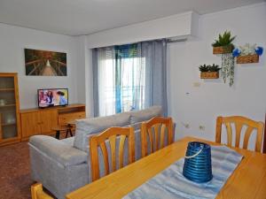 Playa de GandiaにあるROMA XII - Apartamento Familiarのリビングルーム(テーブル、ソファ付)