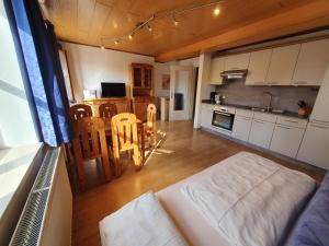 a living room with a couch and a kitchen at Gästehaus Kirchenbauerhof in Bubesheim