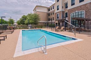 a swimming pool with chairs and a building at Staybridge Suites Austin Northwest, an IHG Hotel in Austin