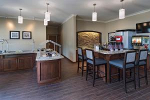 a large room with a bar with chairs and a kitchen at Staybridge Suites Austin Northwest, an IHG Hotel in Austin