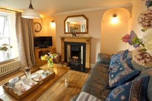 a living room with a couch and a fireplace at Vine Cottage in Penpillick