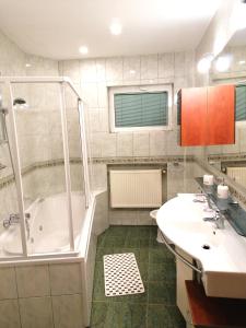 a bathroom with a shower and a tub and a sink at Diamond Apartments in Bucharest +55 photos