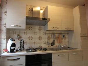 a kitchen with a sink and a stove top oven at Tra le Vette in Caspoggio