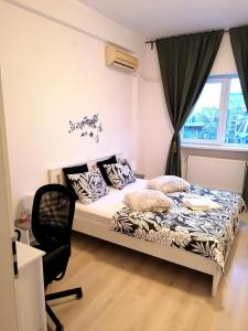 a bedroom with a bed and a chair and a window at Diamond Apartments in Bucharest