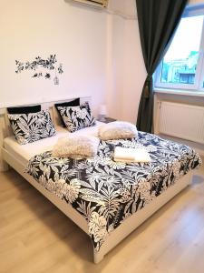 a bed with a black and white comforter and pillows at Diamond Apartments in Bucharest