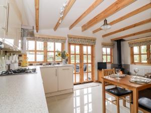 a kitchen with wooden ceilings and a table with chairs at Someplace Else in Diss