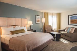 a hotel room with a bed and a chair at Candlewood Suites Fort Collins by IHG in Fort Collins