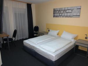 ein Hotelzimmer mit einem Bett und einem Schreibtisch in der Unterkunft Hotel National in Koblenz