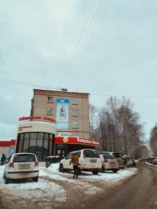 a snow covered street with cars parked in front of a building at ОК! Красноармейская, 101 in Tomsk