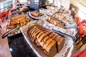 a buffet with many different types of bread on display at Hotel Mares do Sul in Tramandaí