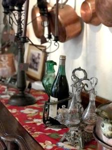 una mesa con botellas de vidrio y una lámpara en ella en U Fragnu di perruccio, en Levie