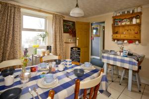 a dining room with a blue and white table and chairs at Vine Cottage in Penpillick +63 photos
