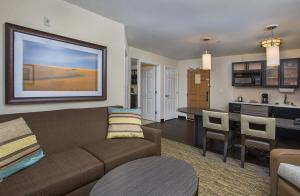 a living room with a couch and a kitchen at Candlewood Suites Bowling Green by IHG in Bowling Green