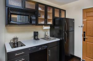 a kitchen with a black refrigerator and a sink at Candlewood Suites Bowling Green by IHG in Bowling Green +35 photos