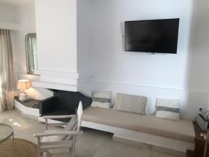 a living room with a couch and a flat screen tv at Villa Denni in Ermioni