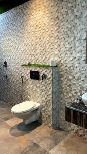 a bathroom with a toilet in a brick wall at Yashogopal Resortico in Vrindāvan