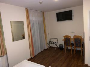 Zimmer mit einem Bett und einem Spiegel sowie einem Tisch und Stühlen in der Unterkunft Hotel National in Koblenz