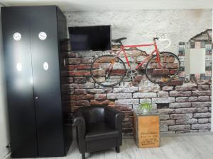 ヴィッテンにあるGästehaus Holidayの赤い自転車が椅子を持ってレンガの壁に掛けられている