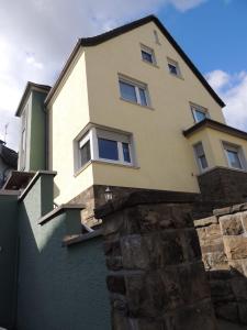 uma casa no topo de uma parede de pedra em Gästehaus Holiday em Witten