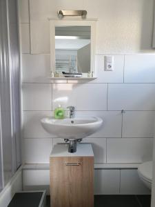 W łazience znajduje się umywalka i lustro. w obiekcie Gästehaus Holiday w mieście Witten