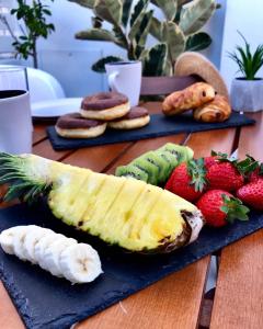 een snijplank met een banaan en fruit op een tafel bij Klm House in Rhodos-stad