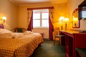 a hotel room with a bed and a desk and a window at Tysfjord Hotel in Storjord I Tysfjord