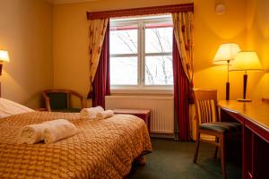 a hotel room with towels on a bed with a window at Tysfjord Hotel in Storjord I Tysfjord