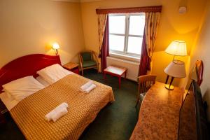 a bedroom with a bed with two towels on it at Tysfjord Hotel in Storjord I Tysfjord
