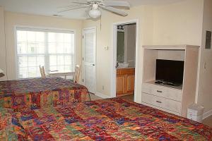 een slaapkamer met een bed en een flatscreen-tv bij Studio Brunswick Plantation Villa 2404L in Calabash